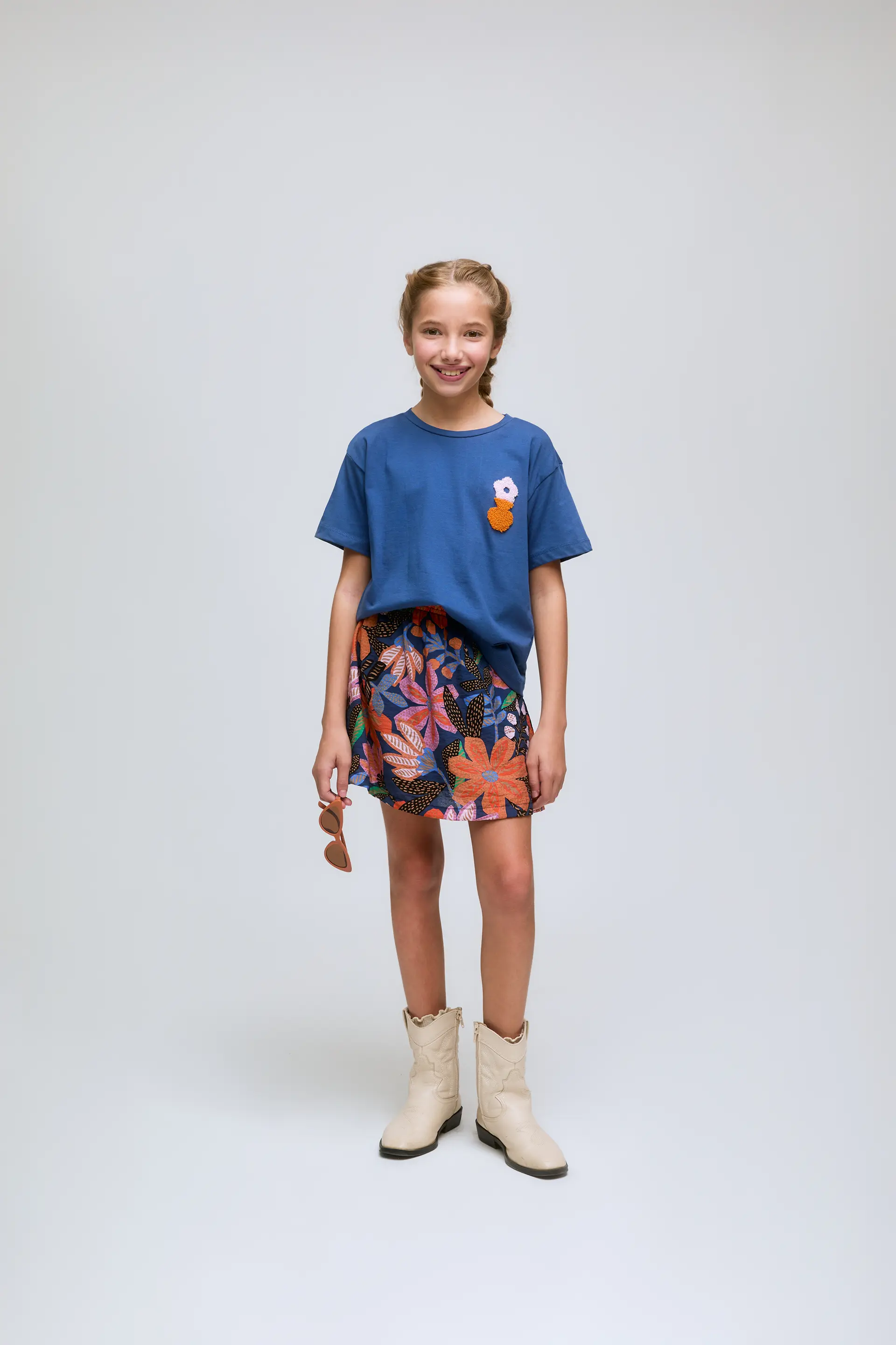 Camiseta azul de niña con bordado de flor.