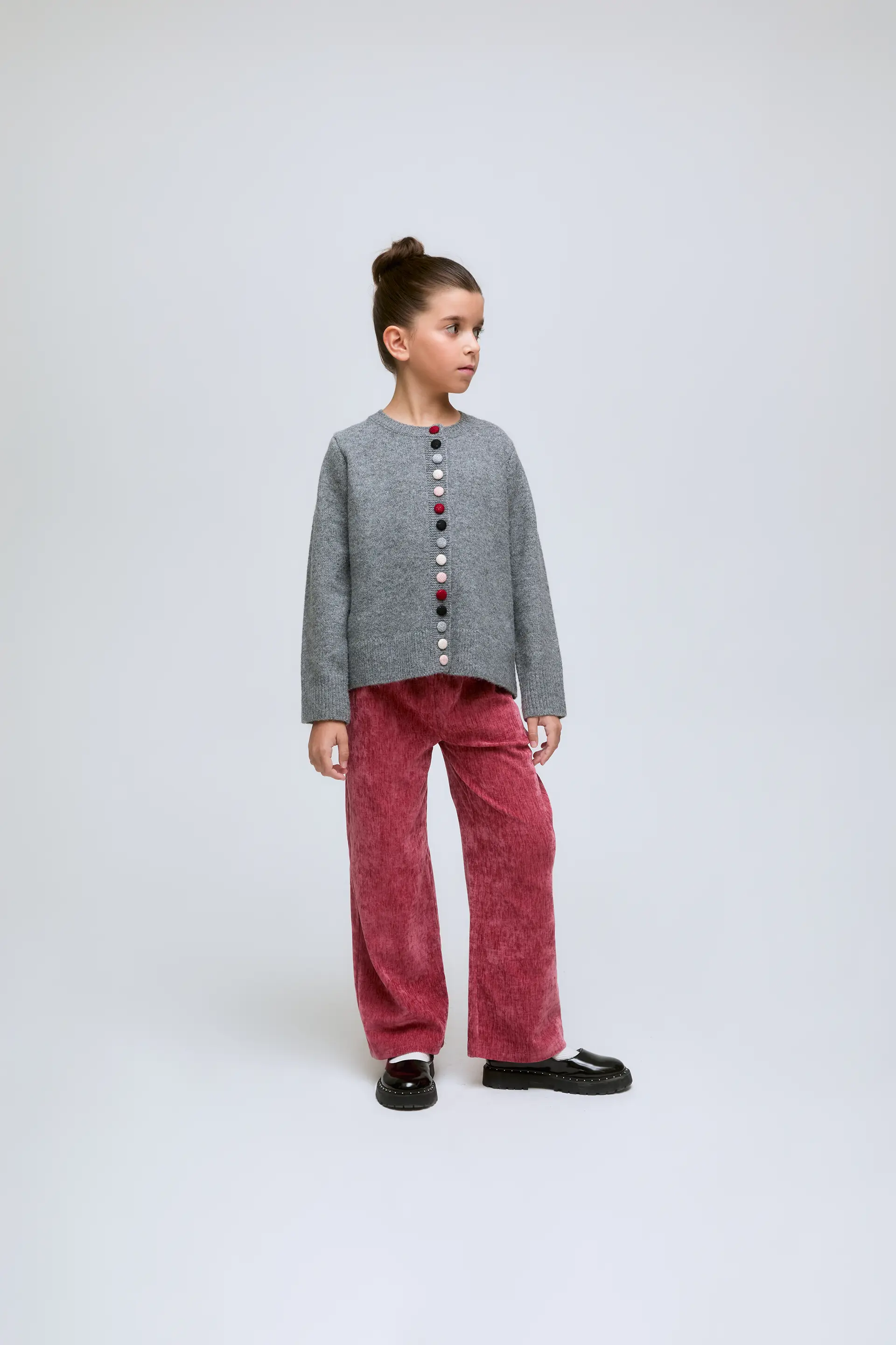 Cardigan de niña gris con cuello redondo y botones.