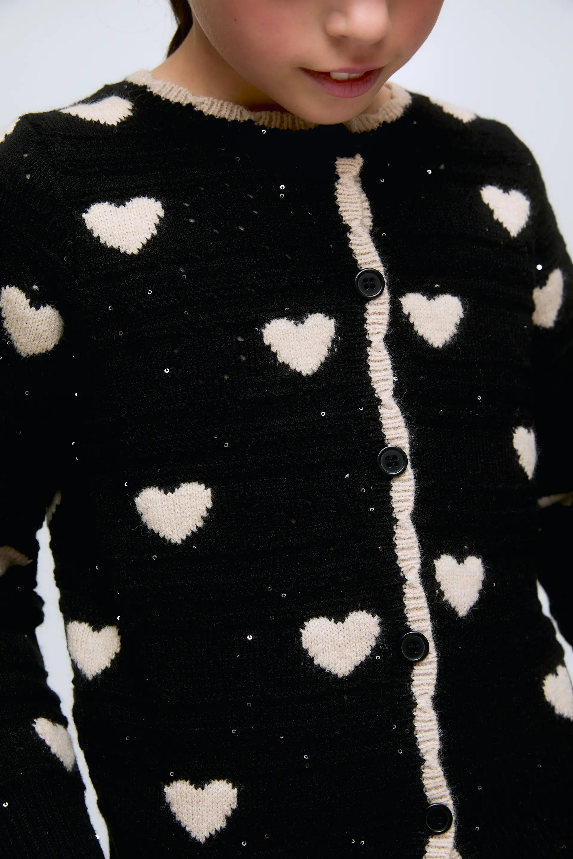 Cárdigan de niña negro con corazones blancos y botones frontales. - Image 3